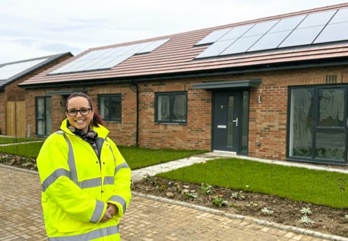 Fiona Ventress wearing a high visibility jacket in front of completed new build homes