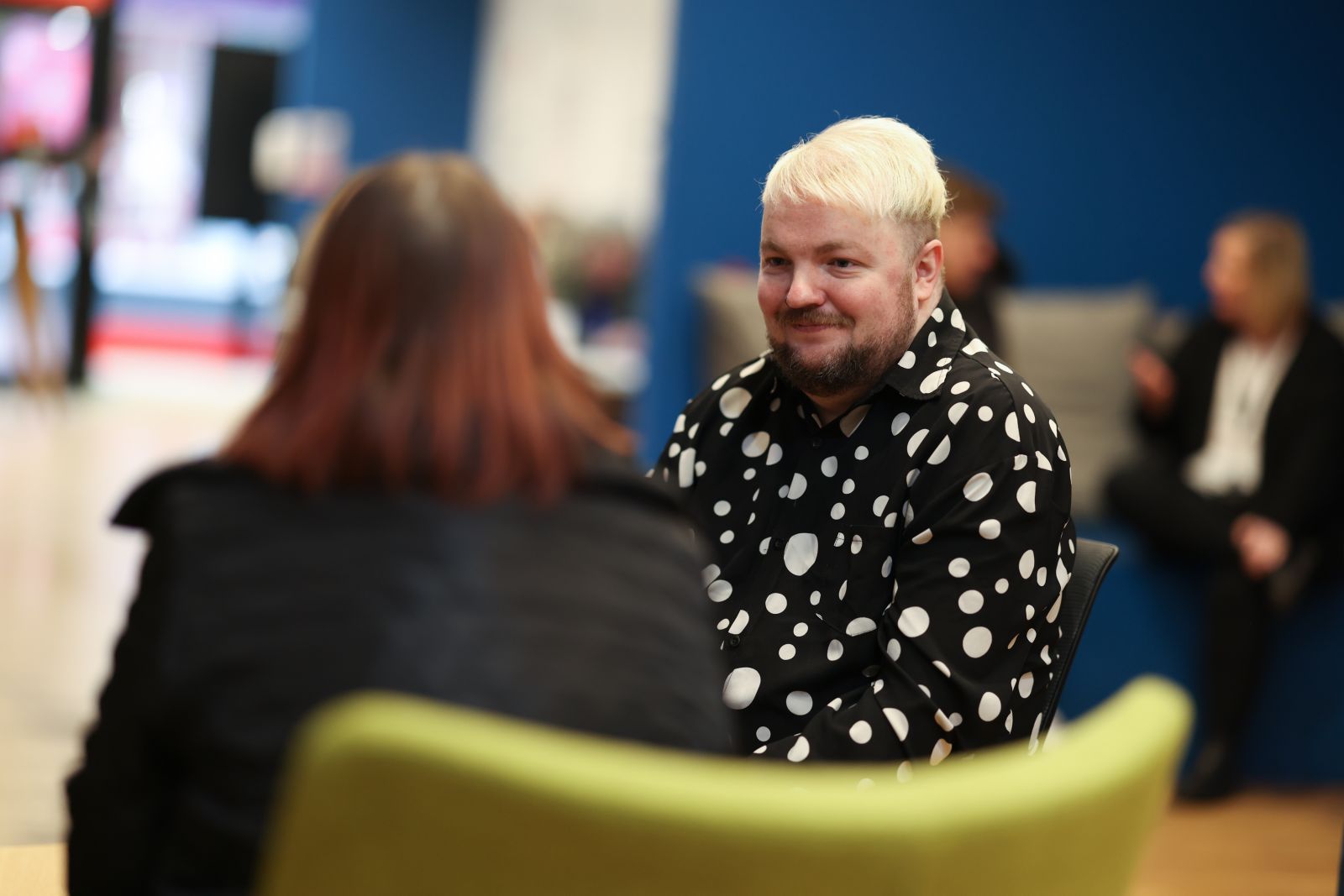 Male customer with sat smiling at female customer