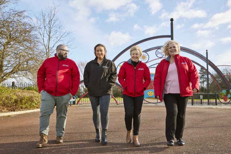 Team of thirteen colleagues walking in Pallister Park, Middlesbrough