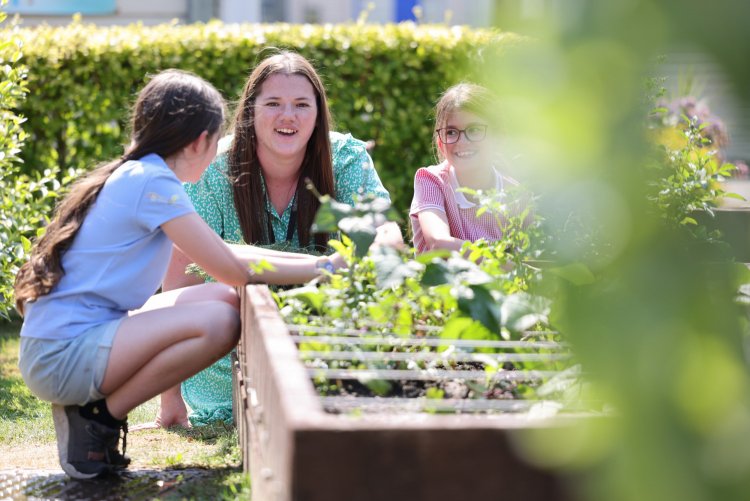 Colleague from Thirteen engaging with children at an allotment. 